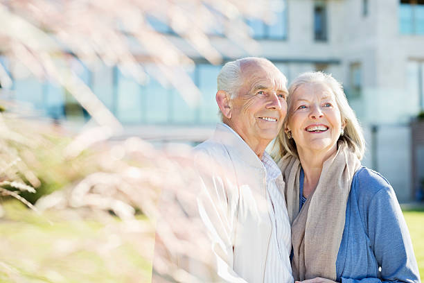 Couple de seniors qui sourit devant sa maison de retraite